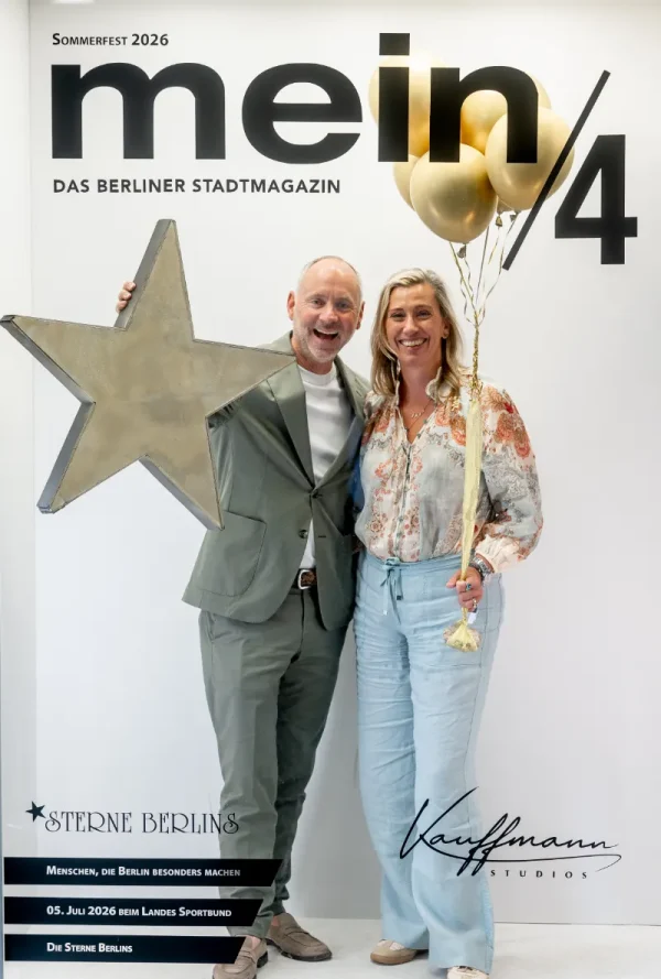Fotobox-Aufnahme: Paar posiert lächelnd mit Stern-Trophäe und goldenen Luftballons